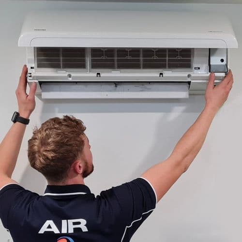 Airomania installer fitting a back-to-back split system air conditioner