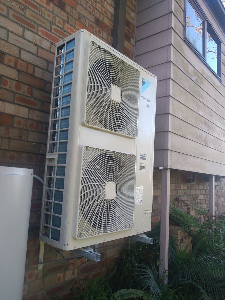 Airomania technician installing a wall-mounted air conditioning unit